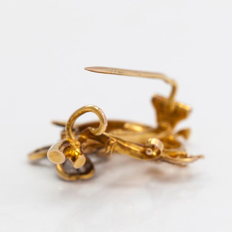 A 14K gold brooch set with rose-cut diamonds and a ruby.