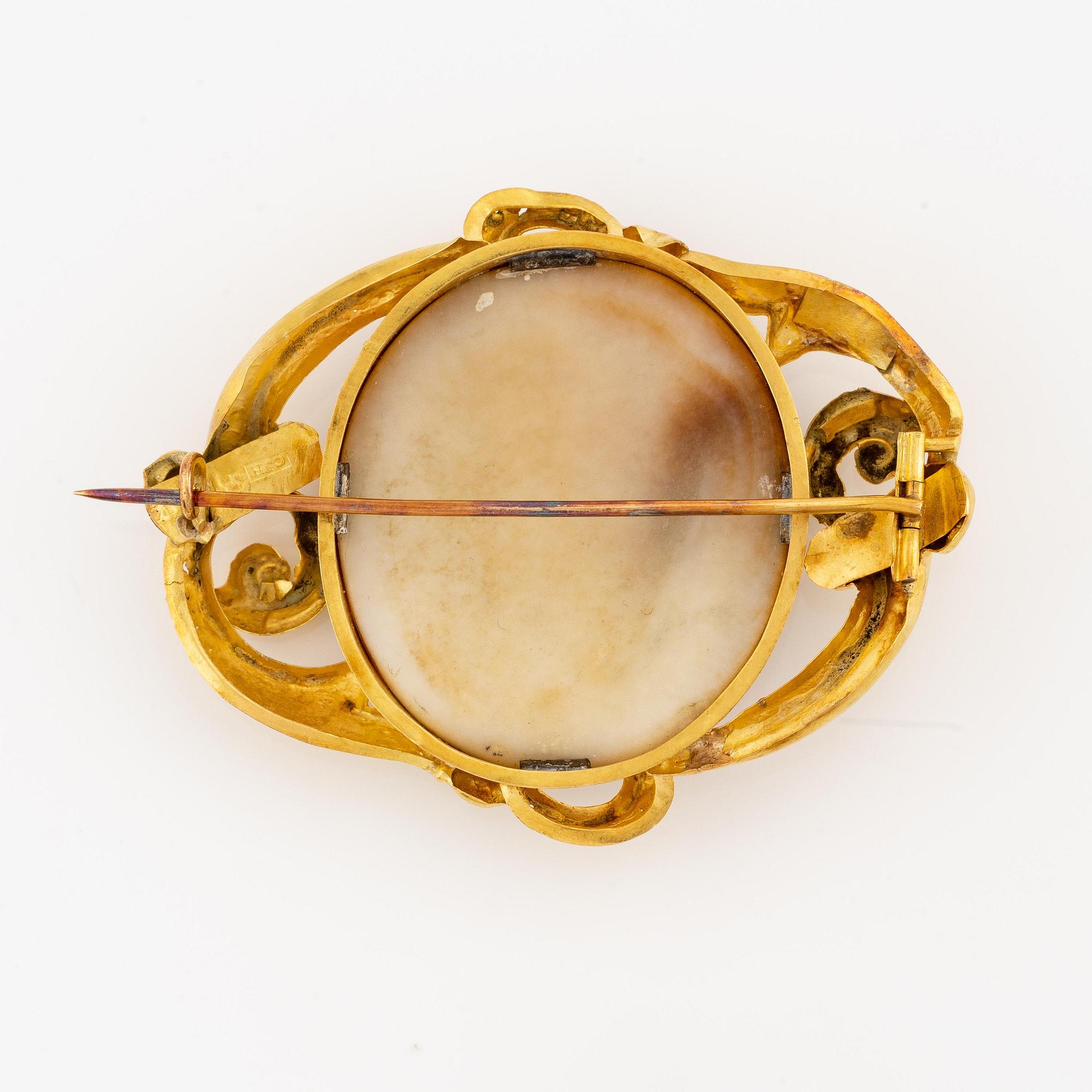 An 18K gold brooch with a hardstone cameo.