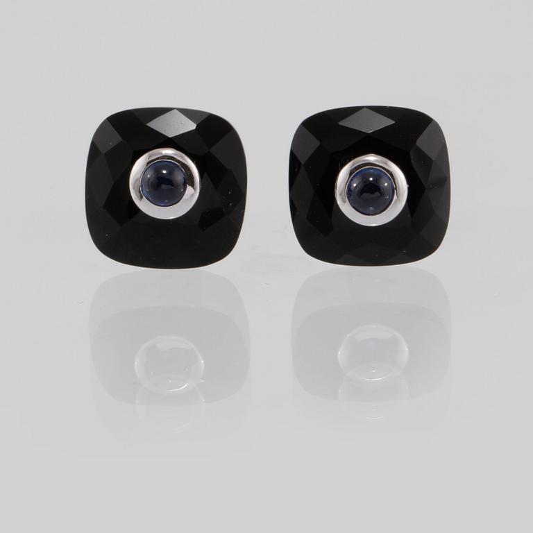 MANSCHETTKNAPPAR, 14K vitguld med checkerslipad onyx samt cabochonslipade blå safirer 0.76 ct. Vikt 8,2 gram.