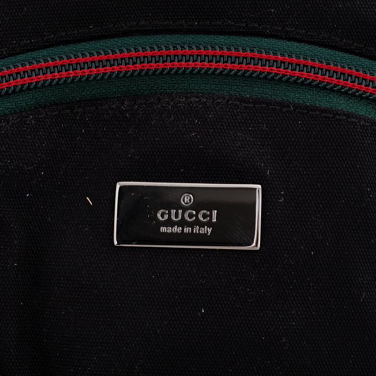 Gucci, a black canvas backpack.