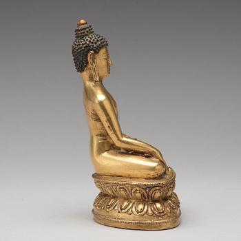 A gilt copper alloy figure of Akshobhya, Tibet, 16th Century.