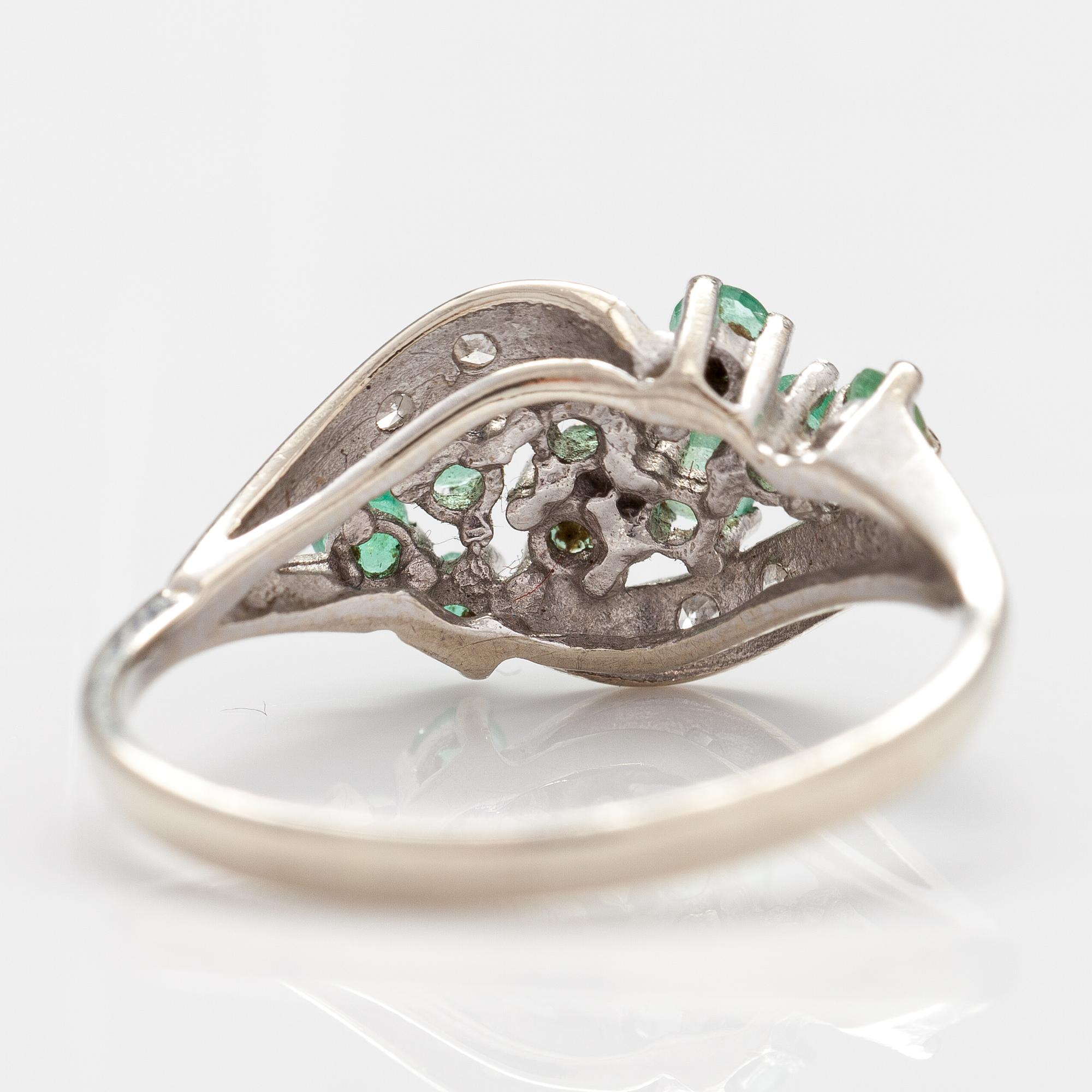 A 14K white gold ring with emeralds and diamonds ca. 0.02 ct in total. Import marked Turun Hopea, Turku 1995.