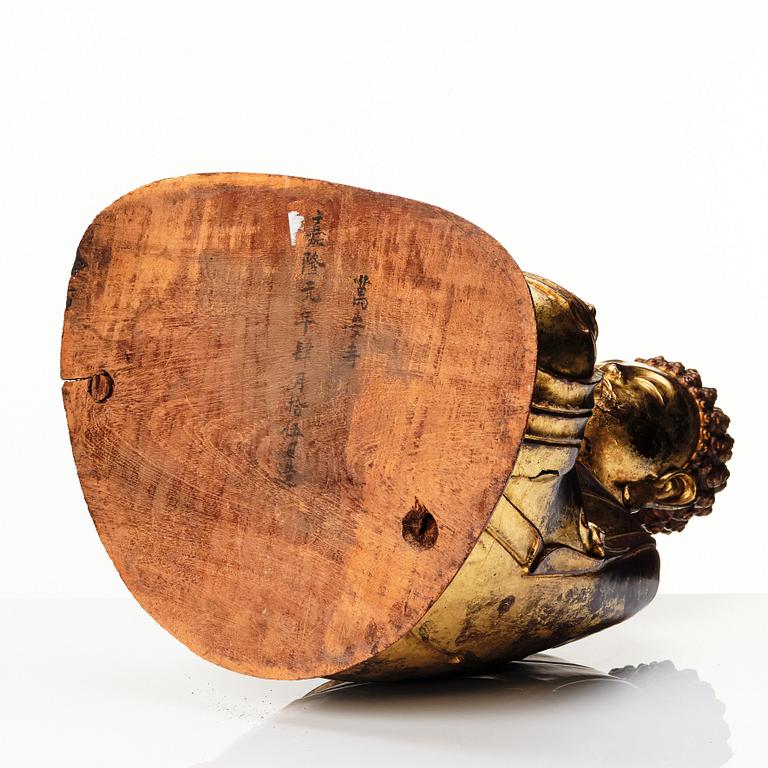 A large gilt and lacquered figure of a seated buddha, Qing dynasty, 19th Century.