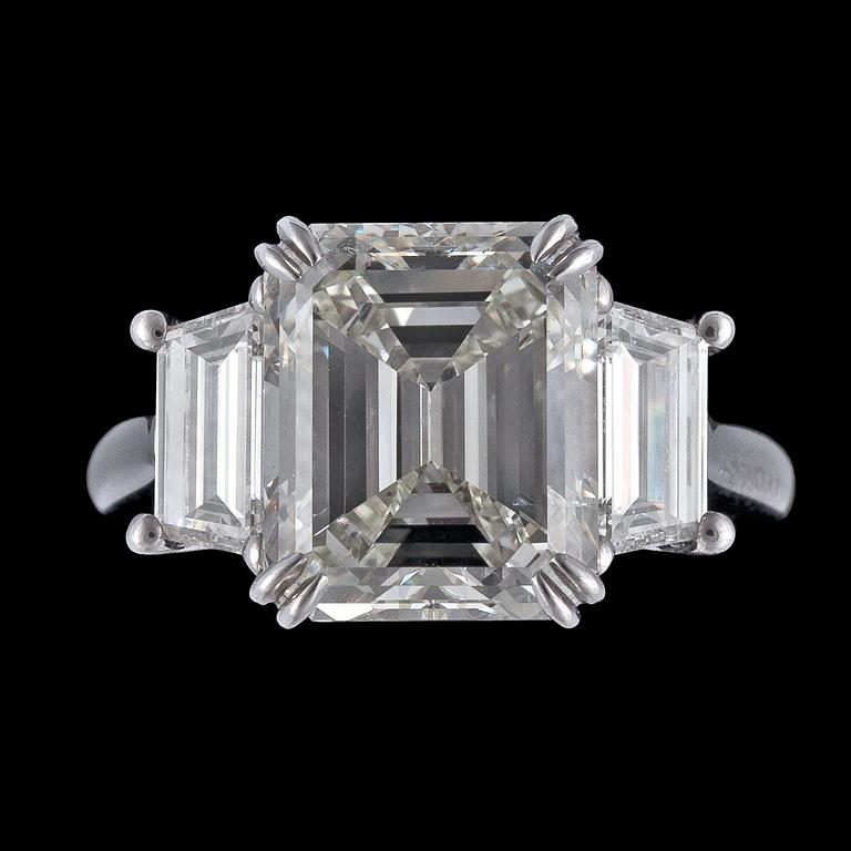 RING, smaragdslipad diamant, 6.27 ct samt mindre smaragdslipade diamanter på vardera sida.