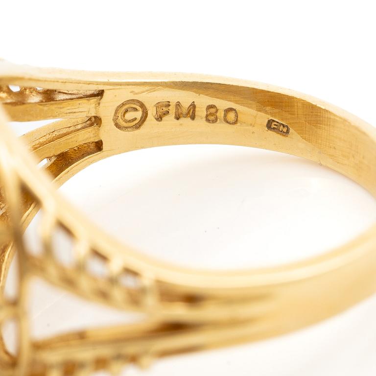 18K gold ring with small emeralds and a round brilliant-cut diamond.