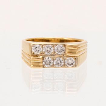 An 18K gold ring set with round brilliant cut diamonds.