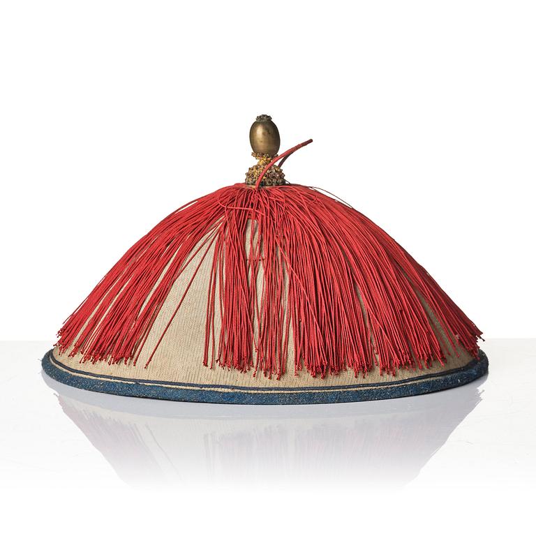 Two boxes with a mandarin's summer hat and black satin autumn hat and feather with six mandarin hat insignias.