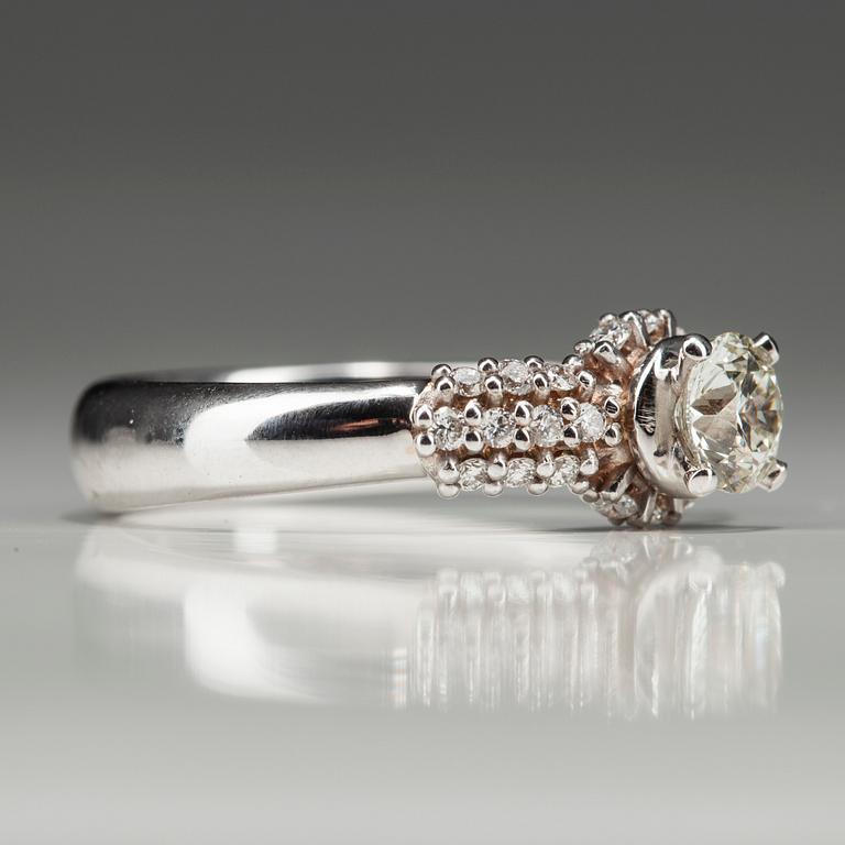 RING, vitguld 18K med diamanter. Mittstenen 0,52 ct L/SI1. 26 små diamanter tot 0,35 ct H/SI1. Intyg.