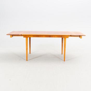 A 1940s mahogany and walnut dining table.
