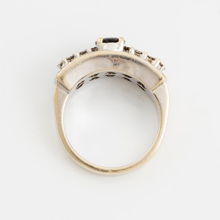 Ring with dark sapphire and brilliant-cut diamonds.