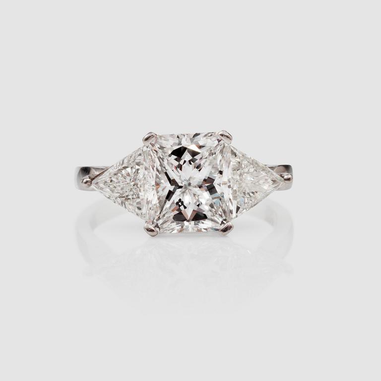 A radiant-cut diamond 3.01 cts ring. Flanked by two triangular cut diamonds, 0.50 ct each. E/VS2, certificate from HRD.