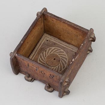 A cheese mould, dated 1768.