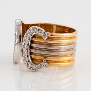 A Cartier "Double C" ring in 18K tri color gold set with round brilliant-cut diamonds.