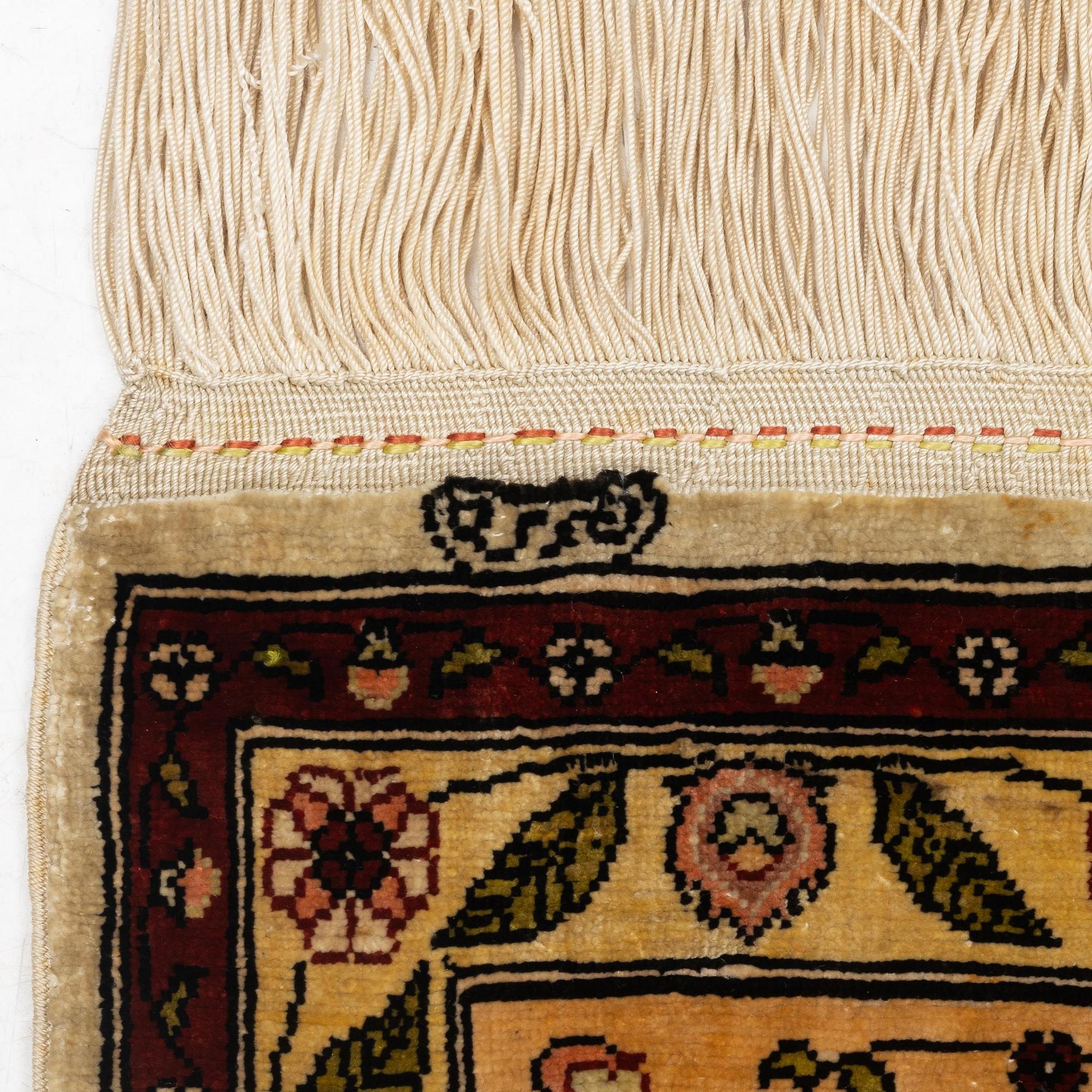 A semi-antique / old silk Hereke rug, West Anatolia, c. 100 x 60 cm.