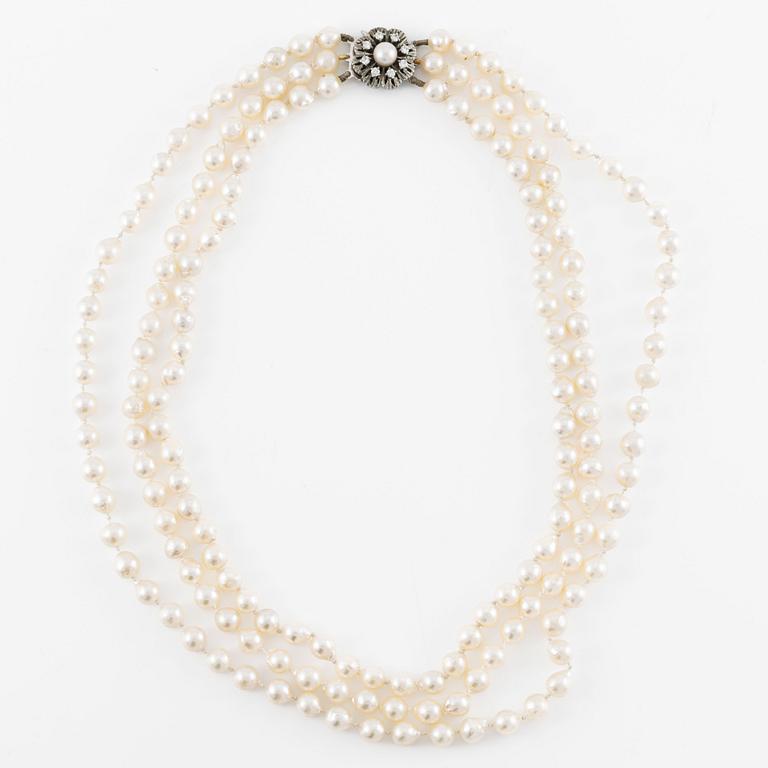 Necklace, three strands of cultured pearls, clasp in silver set with brilliant-cut diamonds.