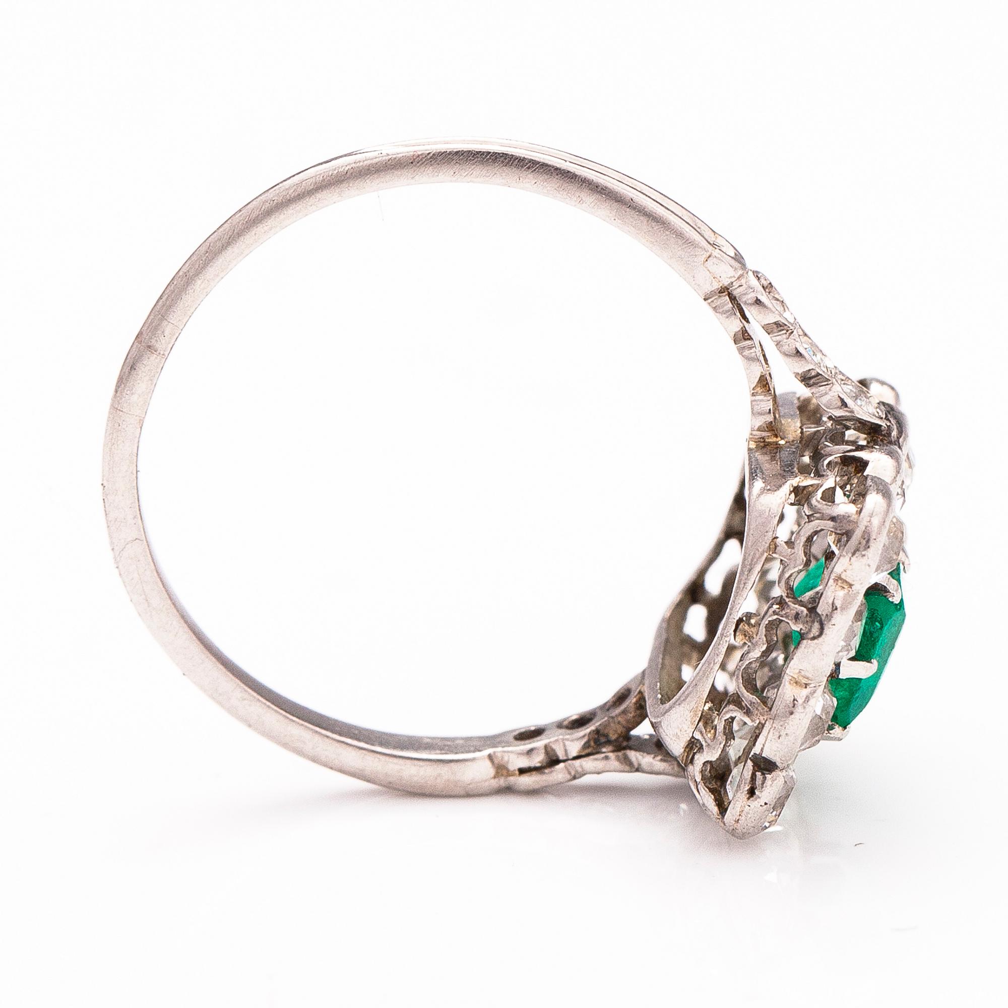 A platinum ring with an emerald ca 0.71 ct and old cut diamonds ca 1.66 ct in total.