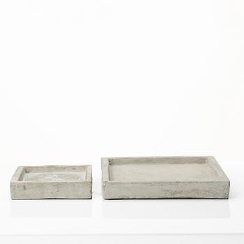 A mixed lot comprising a pair of limestone bookends, a bookshelf and two plates in concrete.