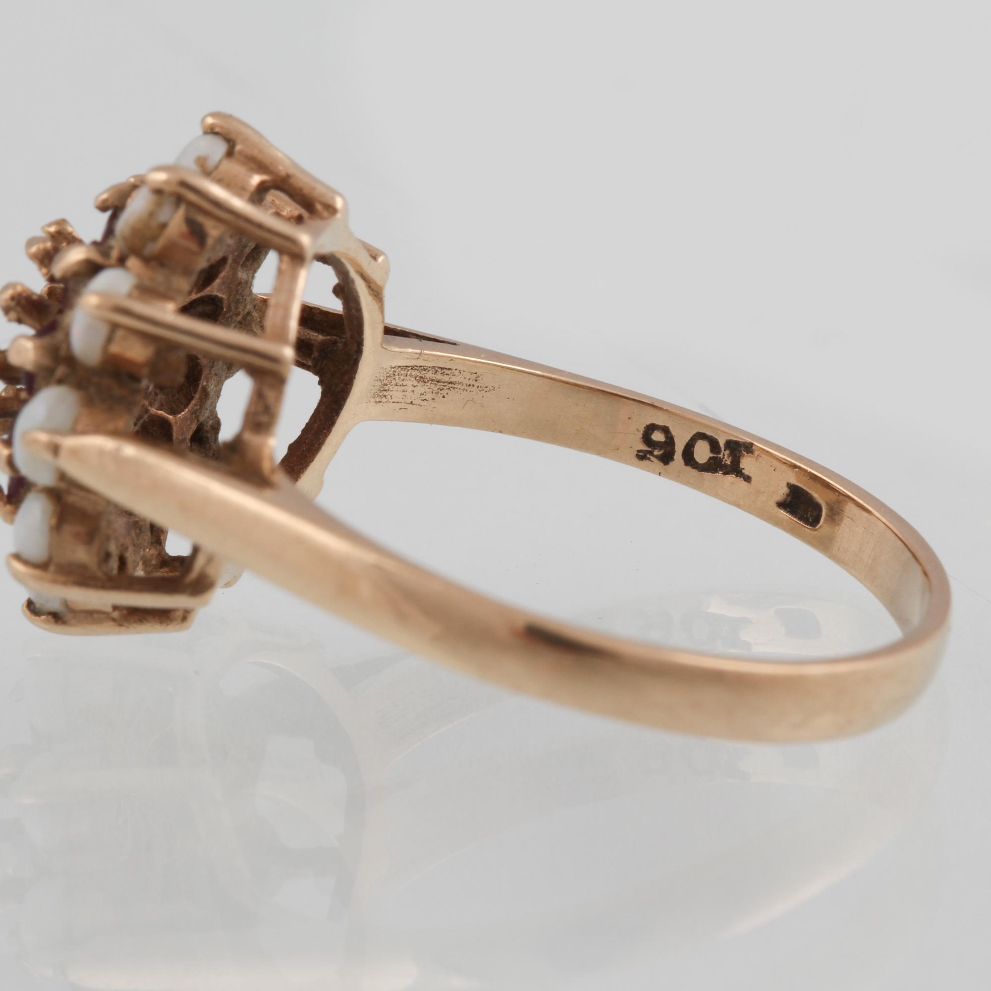 RING, 8K guld med 10 vita opaler samt 10 syntetiska rubiner, troligtvis Sheffield, 1800-talets slut. Vikt 3,4 g.