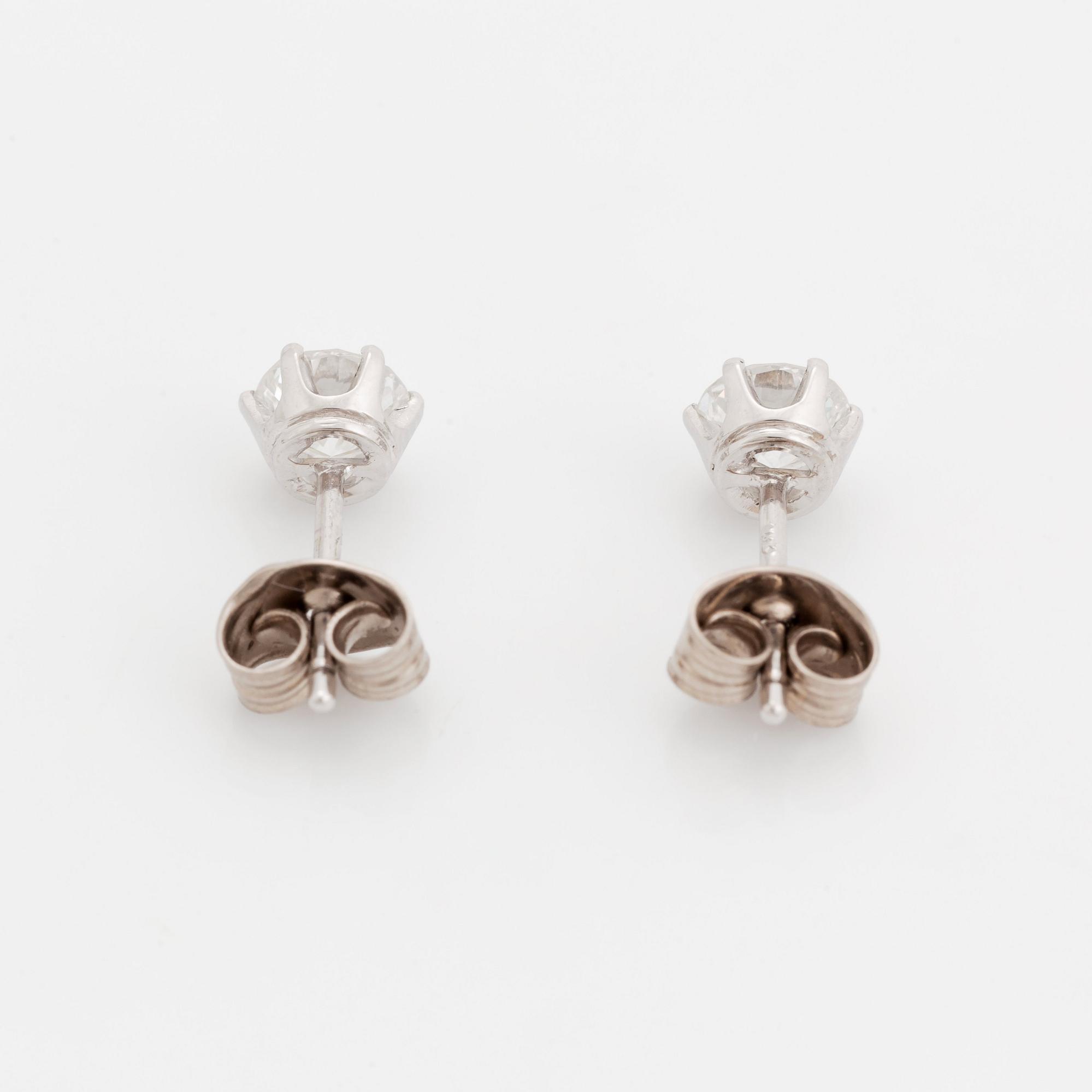 A pair of 18K white gold earrings set with two round brilliant-cut diamonds.