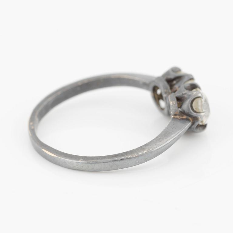 Ring in dark metal, possibly 14K gold, with two old-cut diamonds.