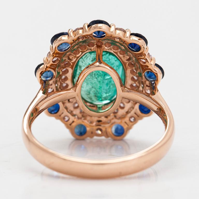 A 14K rosegold ring with an emerald  2.48 ct, sapphires ca 1.17 ct, and diamonds ca. 0.48 ct. With IGI certificate.