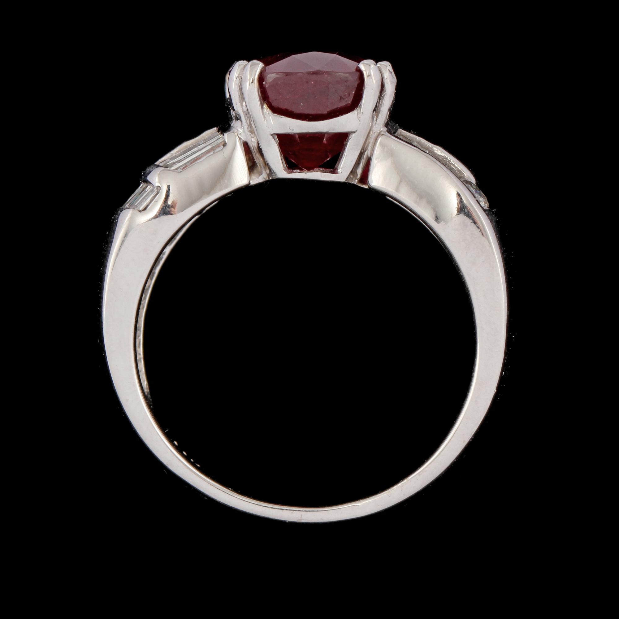 RING, 14k vitguld med ovalslipad rubin ca 6.00 ct samt briljant och trapetsslipade diamanter, ca 1.00 ct. Vikt 10 g.