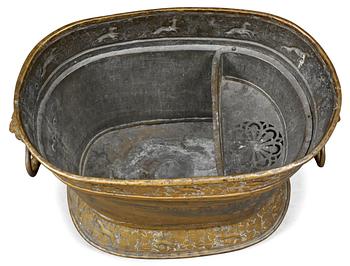 A Baroque brass wine cooler.