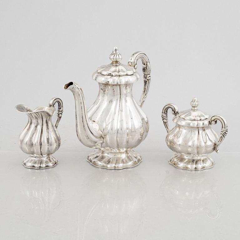 A silver coffee pot, a creamer and a sugarbowl, 20th Century.