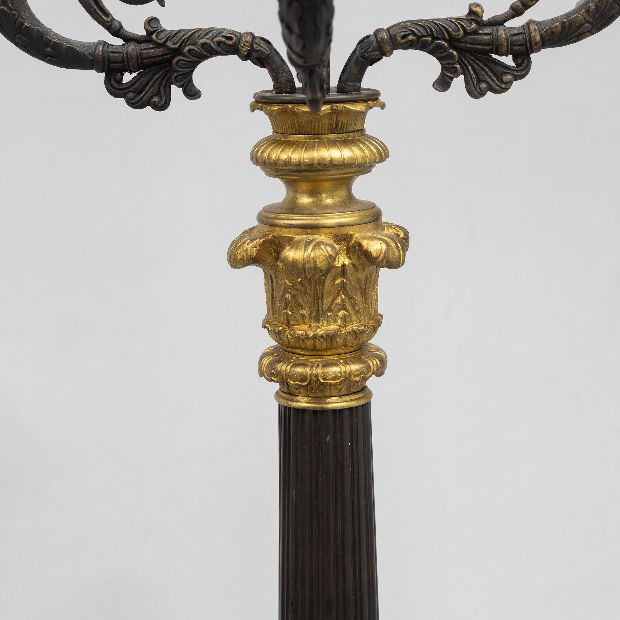 A pair of French Empire-style patinated and gilt bronze five-light candelabra, later part 19th century.