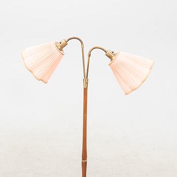 A teak and brass floor lamp from the first half of the 20th century.
