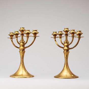 A pair of brass candelabra attributed to Bruno Paul, Germany, early 20th Century.