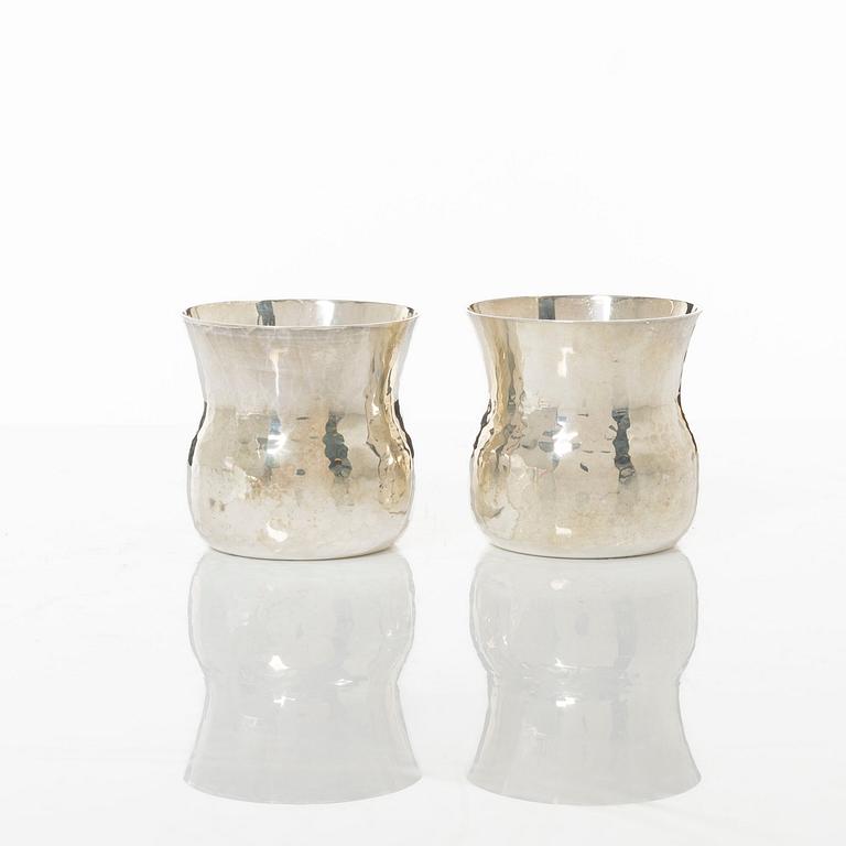 A pair of beakers, two napkin rings, and 17 pieces of cutlery, silver.