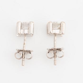 A pair of earrings in 18K white gold set with two round brilliant-cut diamonds.