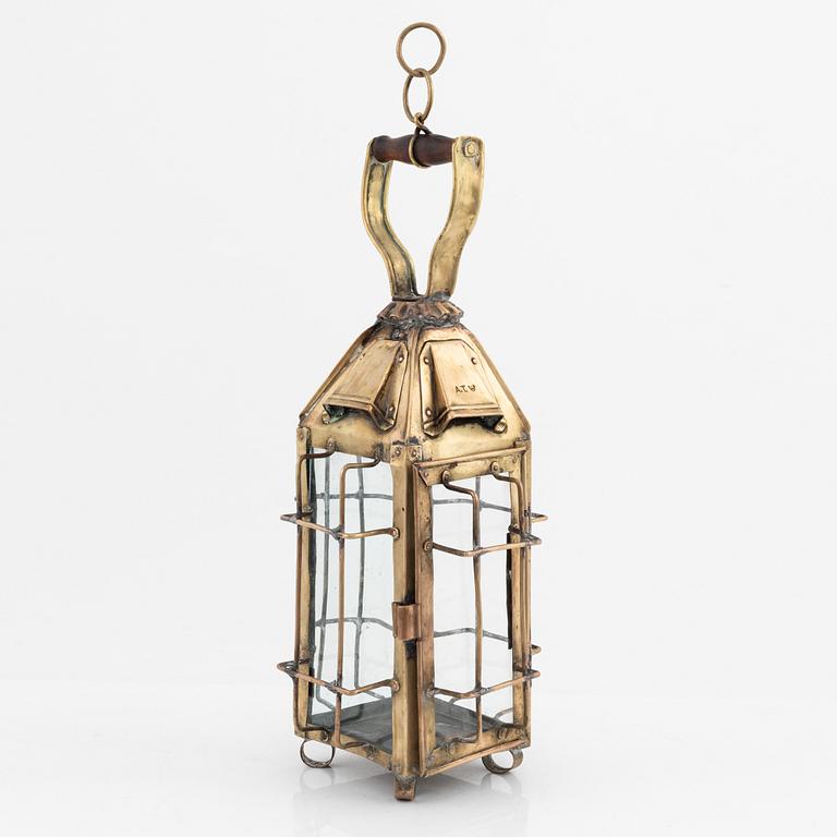 A metal storm lantern, marked A.T, circa 1900.