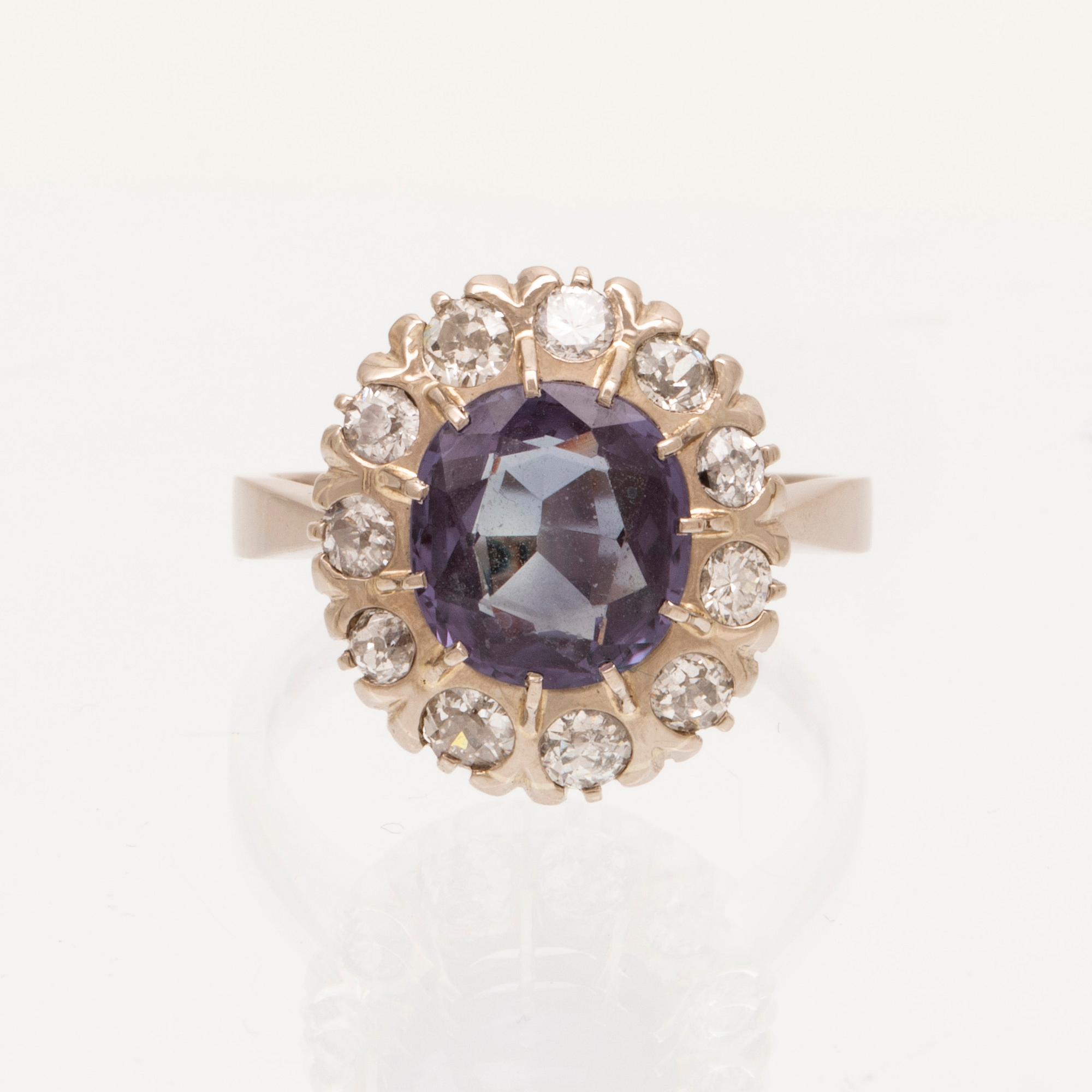 An 18K white gold ring with a colour change synthetic purple sapphire and brilliant and old cut diamonds.