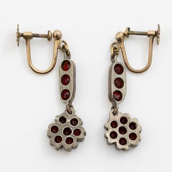 Garniture, necklace/bracelet and earrings in silver with garnets in the form of floral motifs, around the turn of the 20th century.