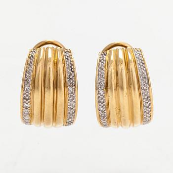 A pair of 18K gold earrings set with small diamonds.