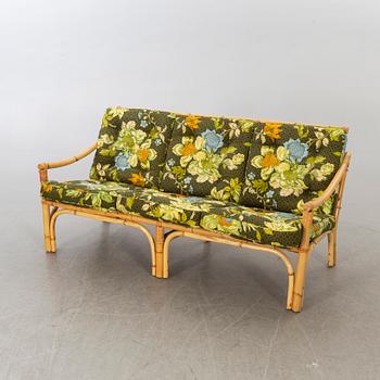 A set of ratten furniture, late 20th century; sofa, armchairs and a lounge table.
