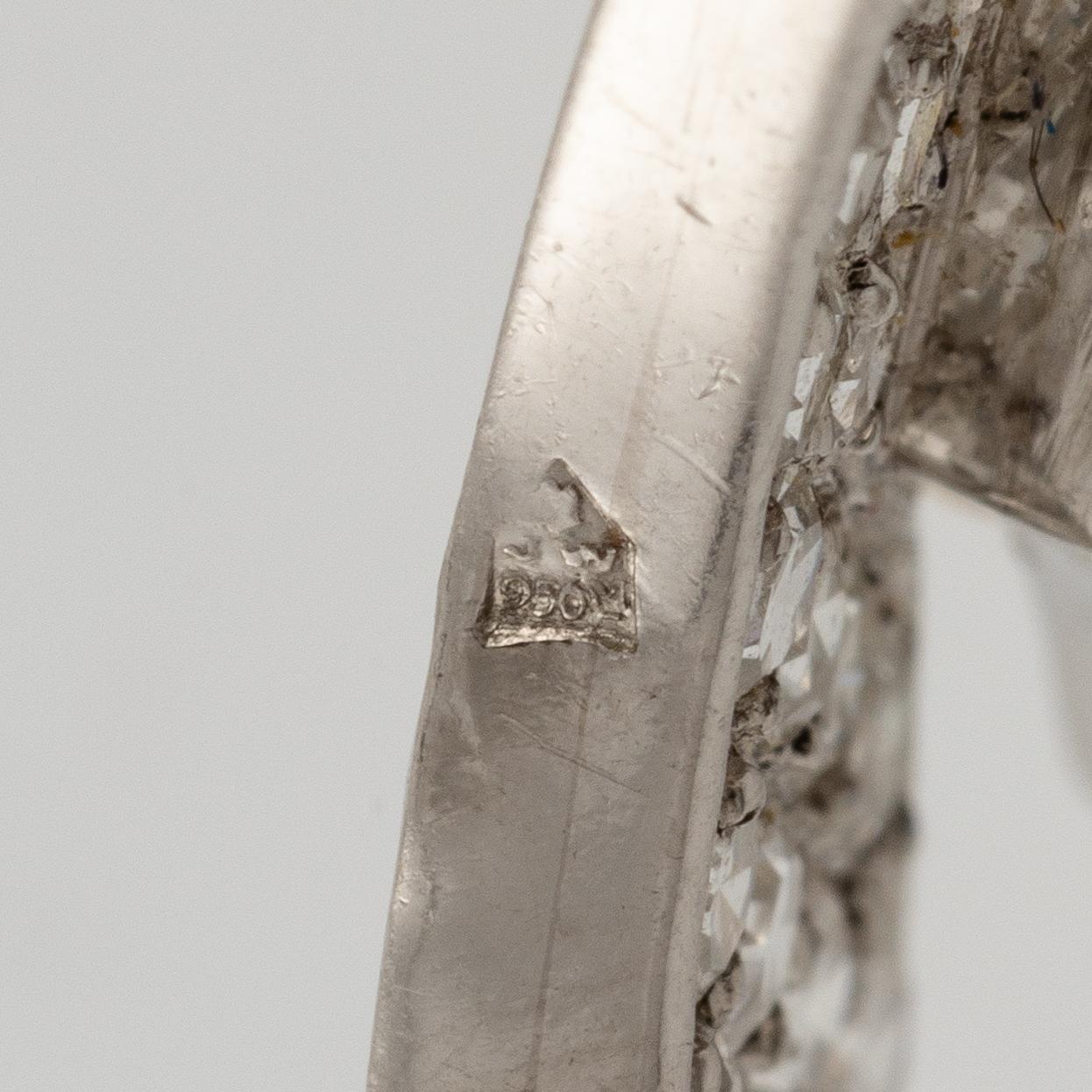 A brooch in platinum in the form of a bow with rubies and diamonds, likely from the 1950s.