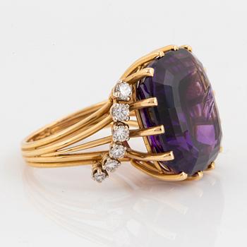 An 18K gold ring set with a faceted amethyst and round brilliant-cut diamonds.