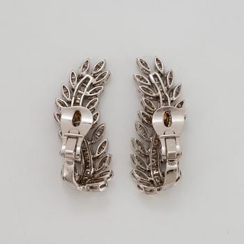 A pair of 18K white gold earrings set with round brilliant-cut diamonds.