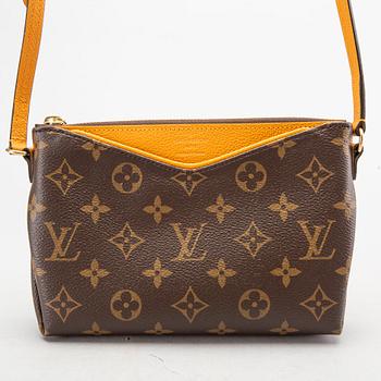 A Louis Vuitton Pallas clutch.