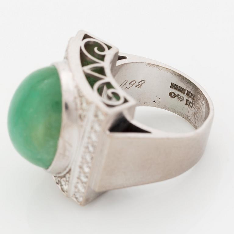An 18K white gold ring set with a cabochon-cut emerald and round- and eight-cut diamonds.