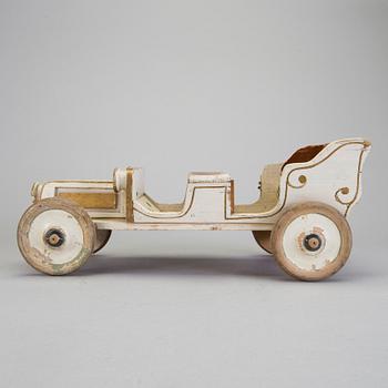 A painted wooden toy car c. 1910.