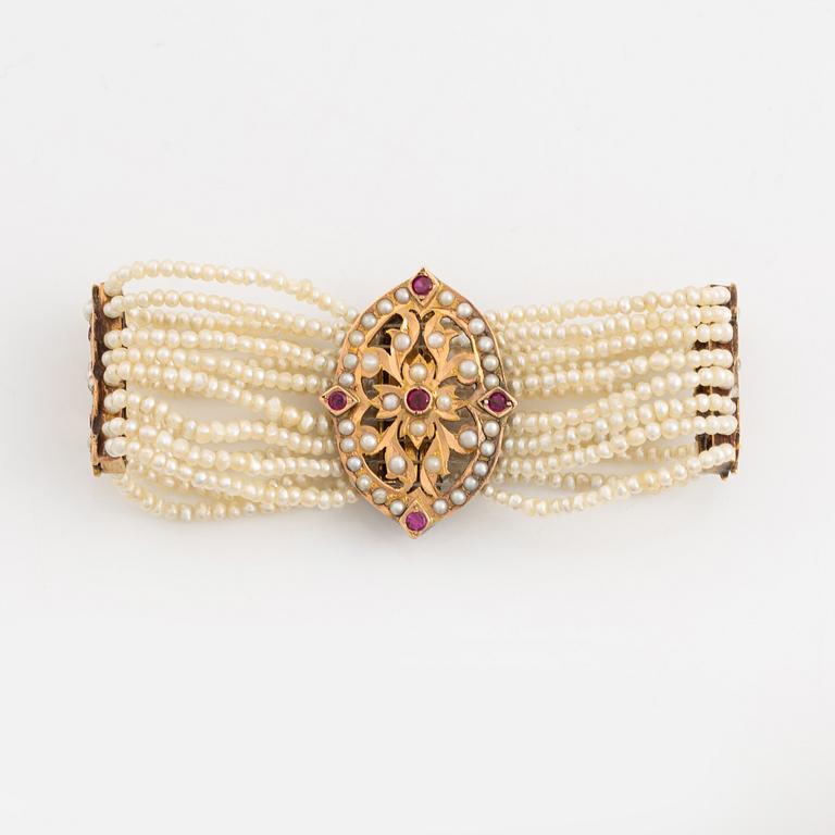 Bracelet, gold, eight-row with seed pearls and rubies.