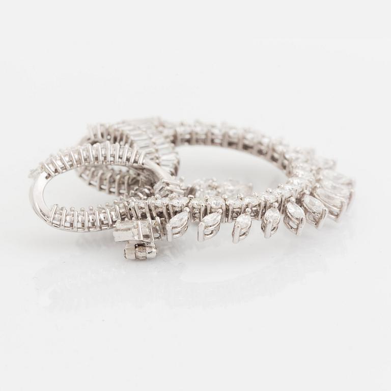 A platinum brooch set with navette-, tapered baguette- and brilliant-cut diamonds.