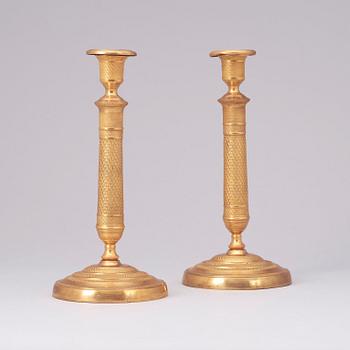 A pair of French Empire early 19th century gilt bronze candlesticks.