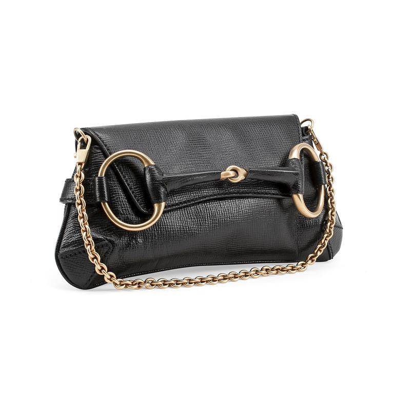 GUCCI, a black embossed leather clutch with a shoulder strap.