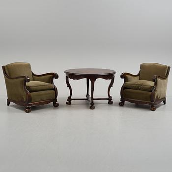 A pair of armchairs and a table, mid 20th century.