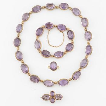 A set with a necklace, a bracelet, a brooch, and a ring.